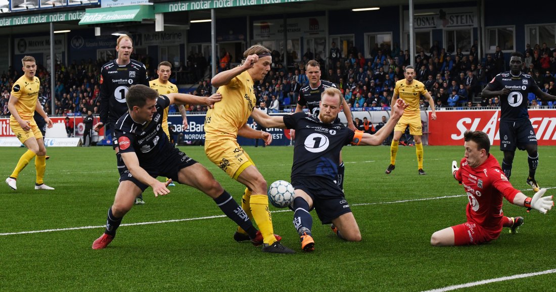 Andreas Hopmark og Dan Peter Ulvestad samarbeider om å stoppe Bodø/Glimts Ulrik Saltnes. På bildet ser vi også flere andre spillere med mange kamper for KBK. Foto: NTB