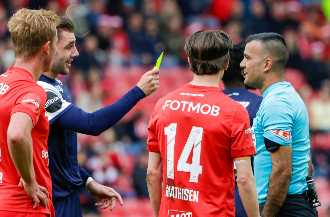 Dommer Rohit Saggi får gult kort av Niklas Ødegård. Foto: NTB