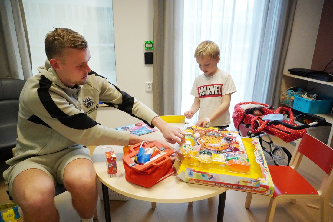 Adrian Sæther hjelper Julian (5) med å pakke ut noen av de nye lekene.